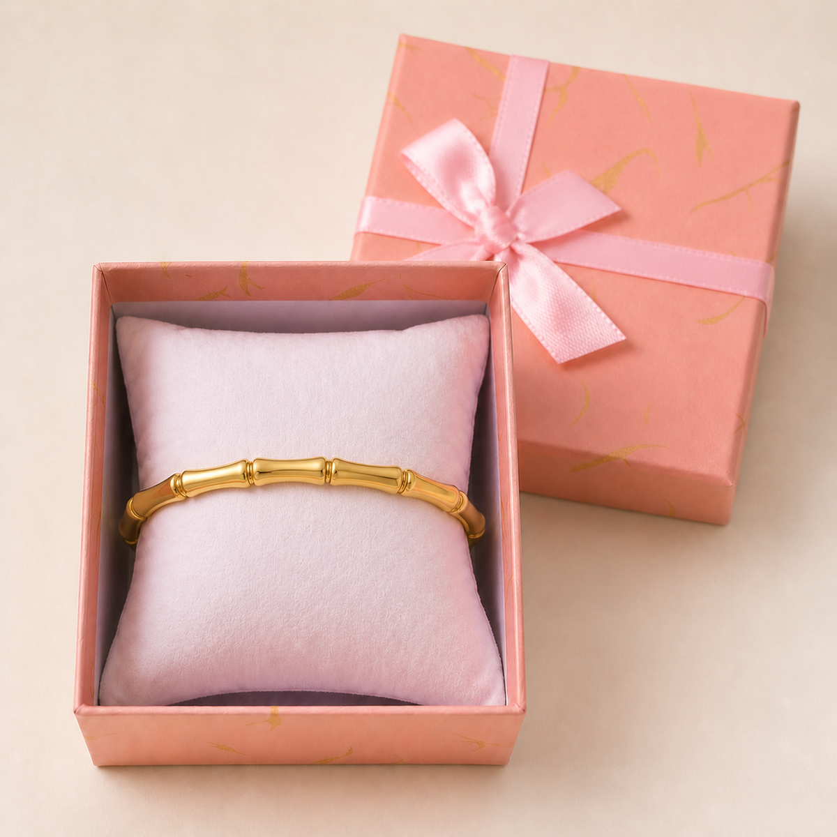 Anti-Tarnish Bamboo kada in an open blush-pink gift box — worn around the cushion